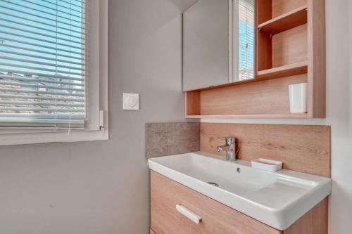 uma casa de banho com um lavatório branco e uma janela em Le 101 - Studio avec mezzanine à 20 min à pied Gare St-Charles em Marselha