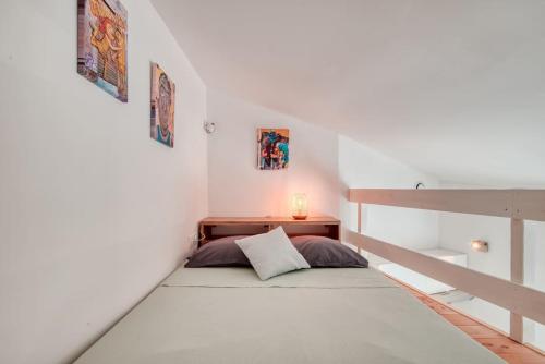 um pequeno quarto com uma cama numa escada em Le 101 - Studio avec mezzanine à 20 min à pied Gare St-Charles em Marselha