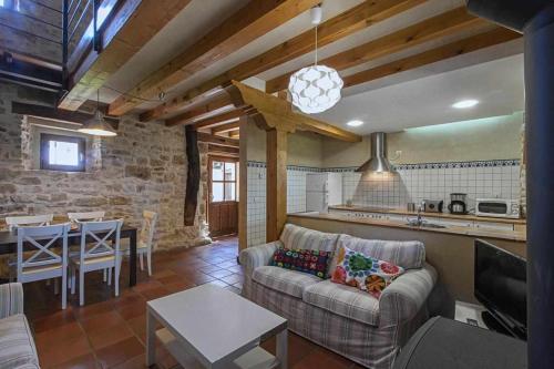 a living room with a couch and a table and a kitchen at Casa Palacio de Mave in Mave