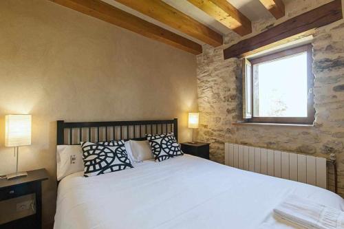 sypialnia z białym łóżkiem z poduszkami i oknem w obiekcie Casa Palacio de Mave w mieście Mave