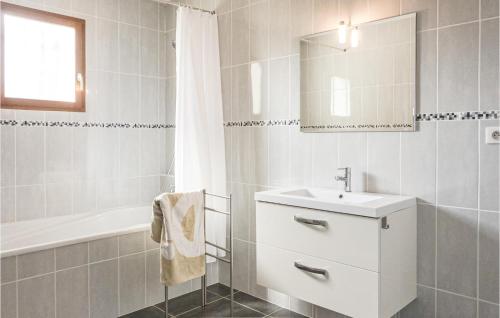 a white bathroom with a sink and a bath tub at 3 Bedroom Cozy Home In Caunes Minervois in Caunes-Minervois