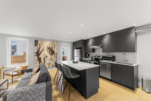 a kitchen and living room with black cabinets at Suites De la Montagne in Montréal