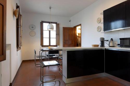 una cocina con armarios negros y sillas. en Palazzo Cecchi Luxury Apartment, en Florencia