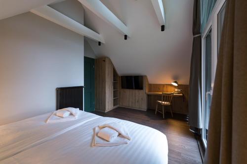 a bedroom with a bed with two white towels on it at Alm-Chalet Premium in Clausthal-Zellerfeld