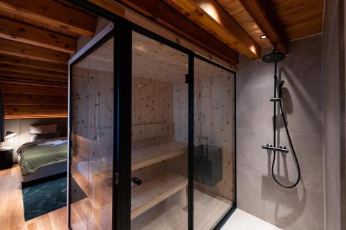 a glass shower in a room with a bed at Alm-Lodge 2 in Clausthal-Zellerfeld