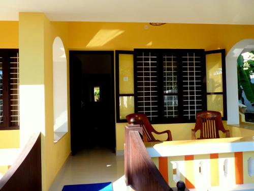 a lobby with two chairs and a black door at La Mirban in Varkala