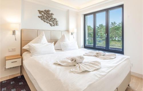 a bedroom with a large white bed with towels on it at Eden in Binz