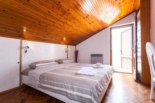 1 dormitorio con 1 cama grande y techo de madera en Apartment in Pakostane with sea view, terrace, air conditioning,WiFi 3475-4 en Pakoštane