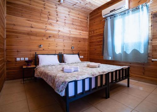 sypialnia z łóżkiem w drewnianej ścianie w obiekcie Gan Hakramim Country Lodging w mieście Kramim