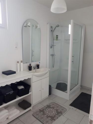 a white bathroom with a shower and a sink at Appart avenue 