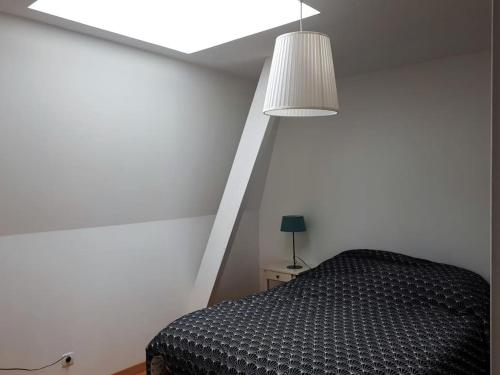a bedroom with a black bed and a lamp at Appart avenue 