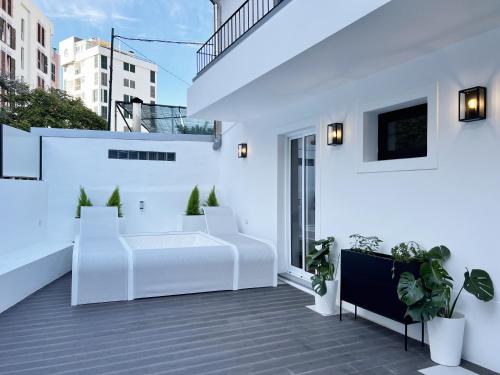 een wit balkon met witte meubels en planten bij Eva Boutique Apartment in Funchal