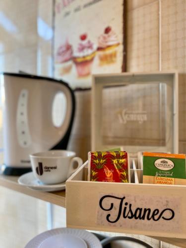 a box on a shelf with a cup of coffee at DREAMS IN ROME - COLOSSEUM APARTMENT in Rome