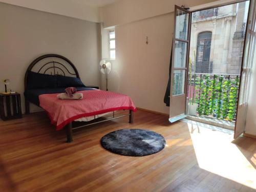 een slaapkamer met een bed en een groot raam bij Departamento 101 La Santisima in Mexico-Stad