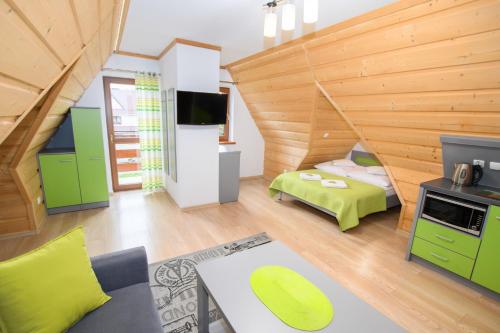Cette chambre comprend un lit et une télévision. dans l'établissement Willa U Futra, à Zakopane