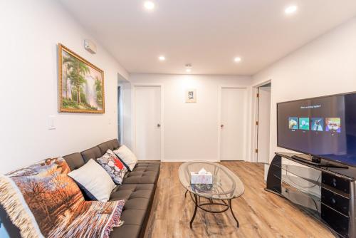 a living room with a couch and a flat screen tv at Southgate 5 Bedroom Vacation Home with Double Garage in Edmonton
