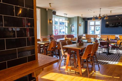a restaurant with tables and chairs in a room at The Red Lion by Innkeeper's Collection in Portsmouth
