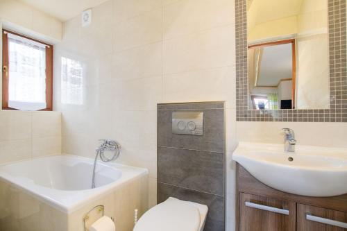 La salle de bains est pourvue d'une baignoire, d'un lavabo et de toilettes. dans l'établissement Willa U Futra, à Zakopane