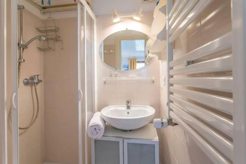 La salle de bains est pourvue d'un lavabo et d'un miroir. dans l'établissement La Bartavelle - Petit duplex avec balcon à proximité des pistes, à Courchevel
