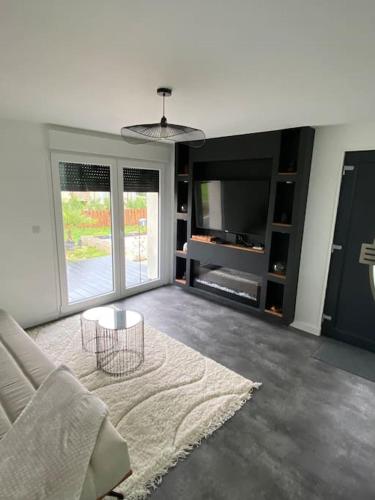 un salon avec un canapé et une table dans l'établissement Makeda Love & Jacuzzi, à Neuville-Saint-Amand