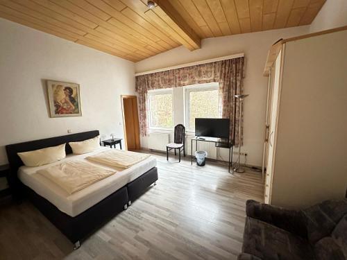 a bedroom with a bed and a flat screen tv at Waldhotel Porta Westfalica in Porta Westfalica