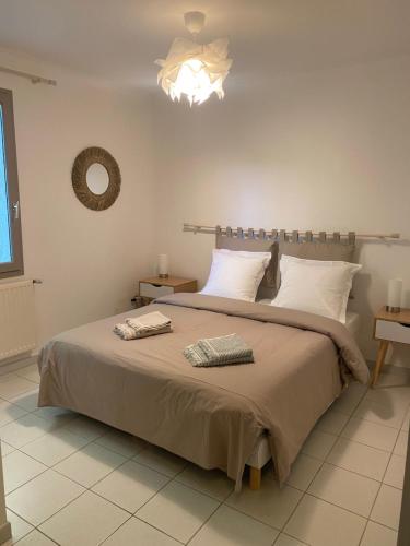 une chambre avec un grand lit et un lustre dans l'établissement La Canopé, à Aubais