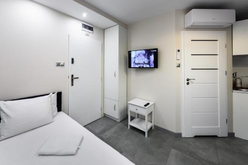 a bedroom with a bed and a tv on a wall at Magnetic apartment Nowogrodzka B in Warsaw