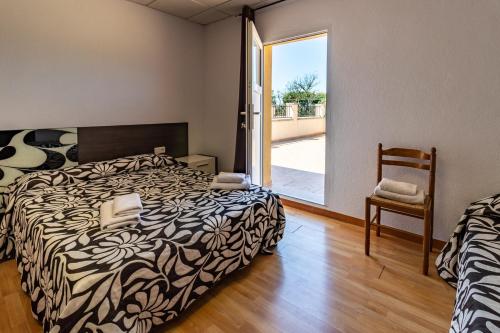 1 dormitorio con 1 cama, 1 silla y 1 ventana en Can Bugantó amplia casa con piscina y jardín en Llambillas