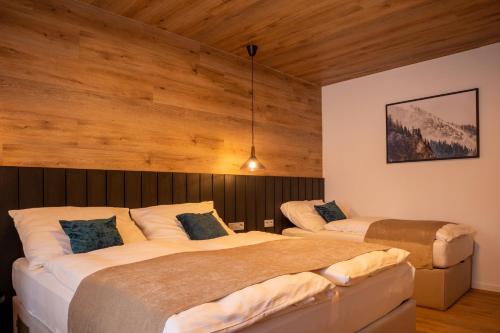 two beds in a room with wooden walls at Hillside No. 18 in Loučná pod Klínovcem