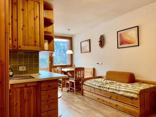 a kitchen and living room with a bed in a room at Monolocale Sans Souci 22 in Madonna di Campiglio