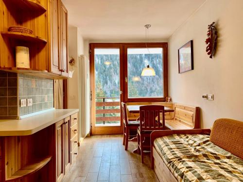 a kitchen and dining room with a table and a window at Monolocale Sans Souci 22 in Madonna di Campiglio