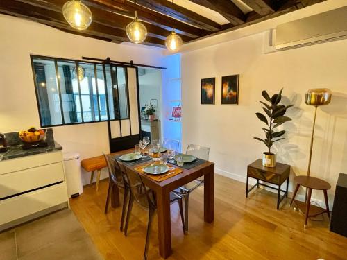 - une salle à manger avec une table et des verres à vin dans l'établissement Designer Apartment Tour Saint-Jacques - 1BR 4P, à Paris
