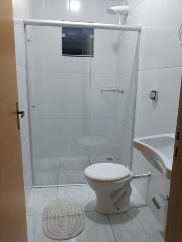 a bathroom with a shower with a toilet and a sink at Recanto Fernandes & Melo in Olímpia