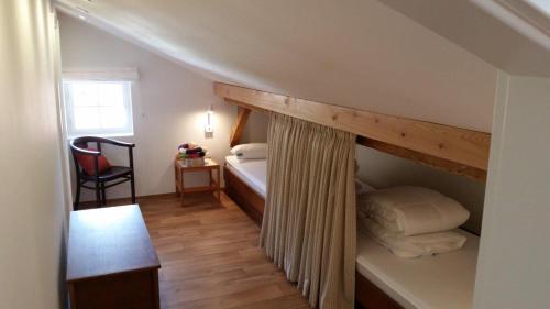ein kleines Schlafzimmer mit einem Bett und einem Fenster in der Unterkunft Haus Malerwinkl in Ramsau bei Berchtesgaden