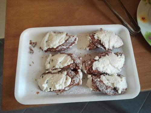 a white dish with ice cream on a table at B&B Cafisu in Paceco
