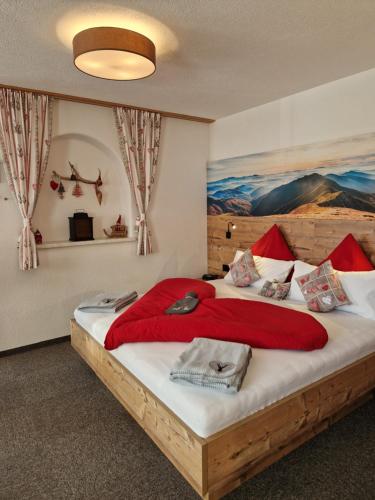 a bedroom with a large bed with a painting on the wall at Haus Haas in Lermoos