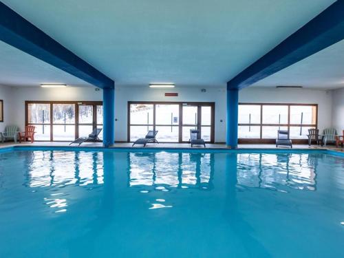 una gran piscina con paredes y ventanas azules en Duplex rénové - 2 chambres 7 personnes vue pistes en Les Orres