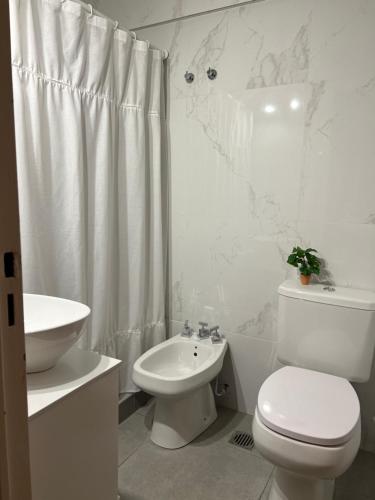 a white bathroom with a toilet and a sink at Monoambiente con cochera. Excelente ubicación. in Mar del Plata