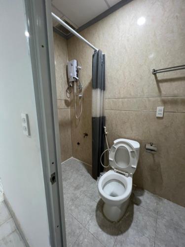łazienka z toaletą i telefonem na ścianie w obiekcie Hello Hotel w mieście Bùi Tiếng