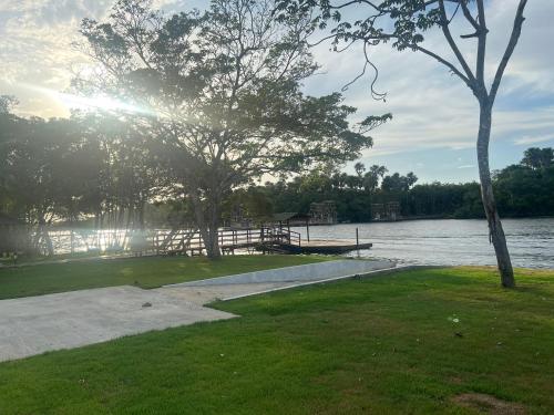a dock next to a lake with the sun shining at Chalé em Barreirinhas in Barreirinhas