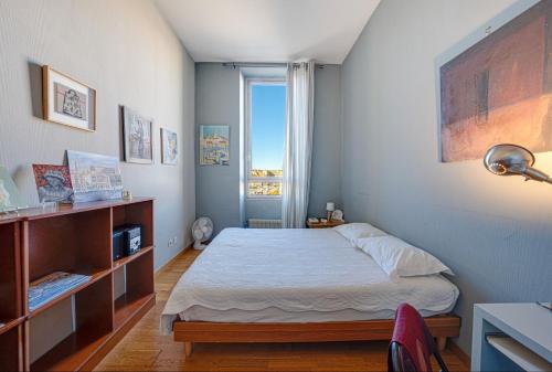 niewielka sypialnia z łóżkiem i oknem w obiekcie Vue sur le port superbe appartement atypique, logement entier w Marsylii