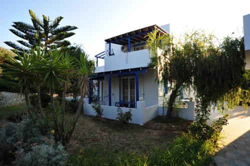 a white house with palm trees in front of it at Anna Ageliki in Damnoni
