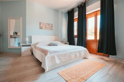 a bedroom with a white bed and a window at Villa Bella Salmagi in Capitana