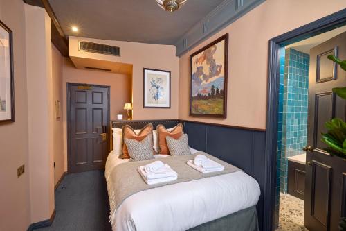a bedroom with a bed with towels on it at Salisbury Arms Hotel in Hertford