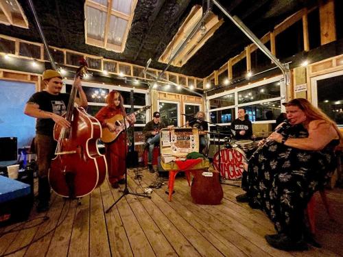 a group of people playing music in a room at The Wanderoo Lodge in Eureka Springs