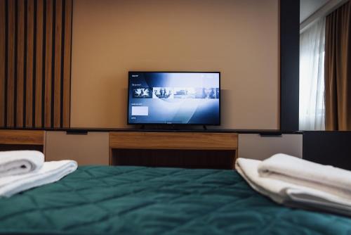 a bedroom with a bed and a television on a counter at Hotel Brčko gas Sarajevo in Lukavica