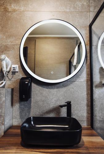 a bathroom with a black sink and a mirror at Hotel Brčko gas Sarajevo in Lukavica
