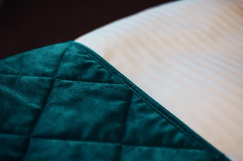 a close up of a green blanket on a bed at Hotel Brčko gas Sarajevo in Lukavica