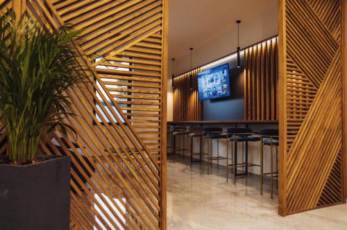 a bar in a restaurant with wooden walls and bar stools at Hotel Brčko gas Sarajevo in Lukavica