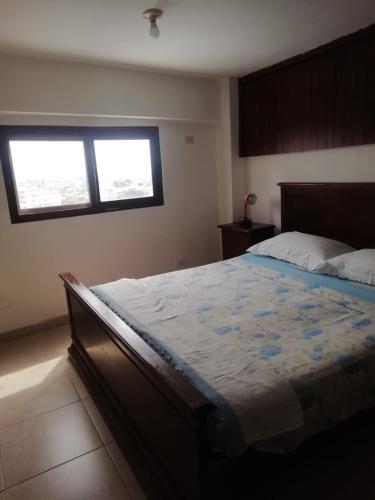 1 dormitorio con 1 cama y 2 ventanas. en Departamento vacacional en Guayaquil